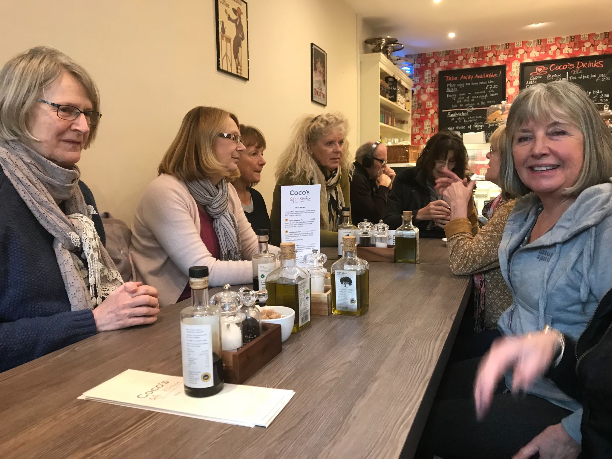 Class members laughing together round a café table after Pilates